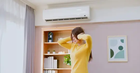 Girl covering her ears because of noisy AC