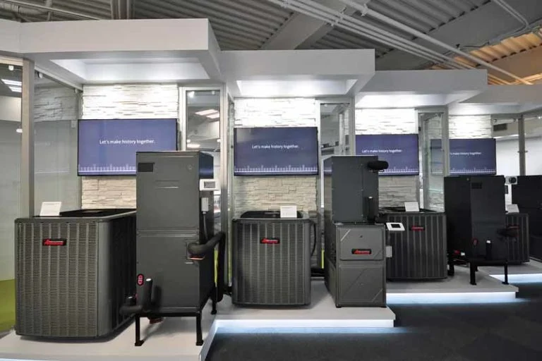A professional showroom features several dark gray heating and cooling systems on display. 